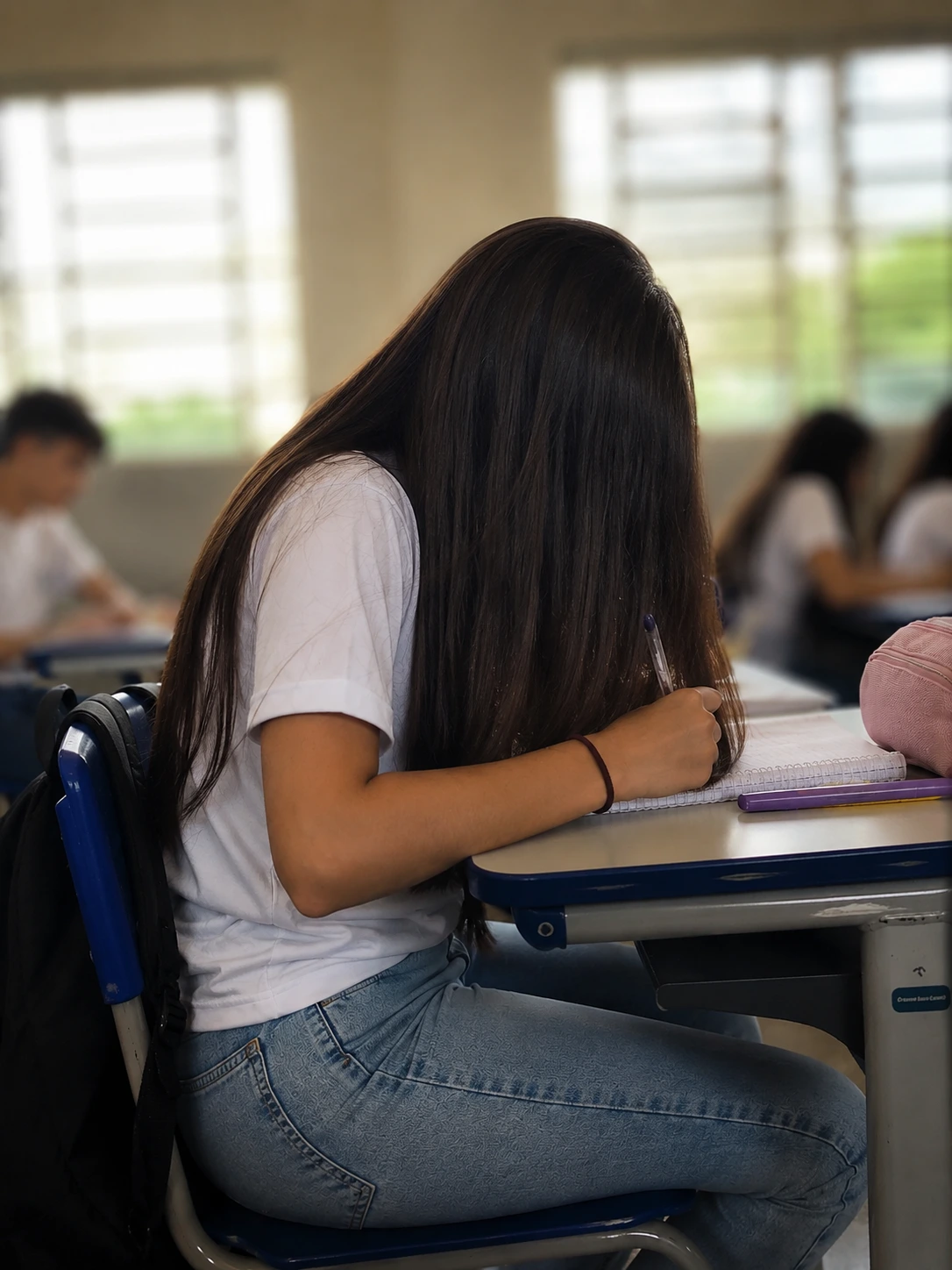 Menina escondendo parte do rosto atrás do cabelo