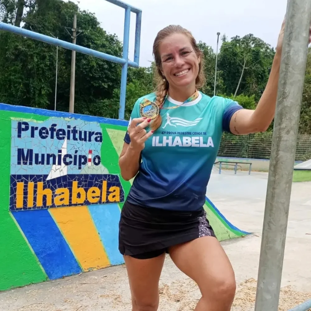 Sarita Del Sol sorrindo com uma medalha da Prova Pedestre Cidade de Ilhabela