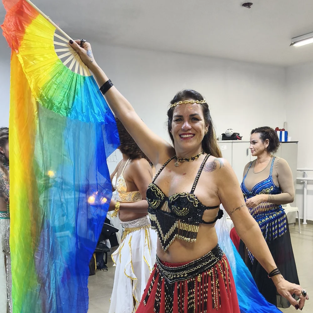 Sarita Del Sol dançando dança do ventre com um leque de véu colorido